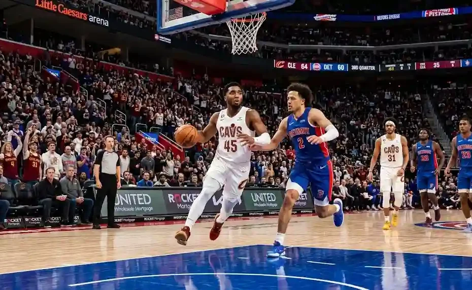 Cleveland Cavaliers guard Donovan Mitchell driving to the hoop past Detroit Pistons defender Cade Cunningham during an NBA game at Little Caesars Arena.